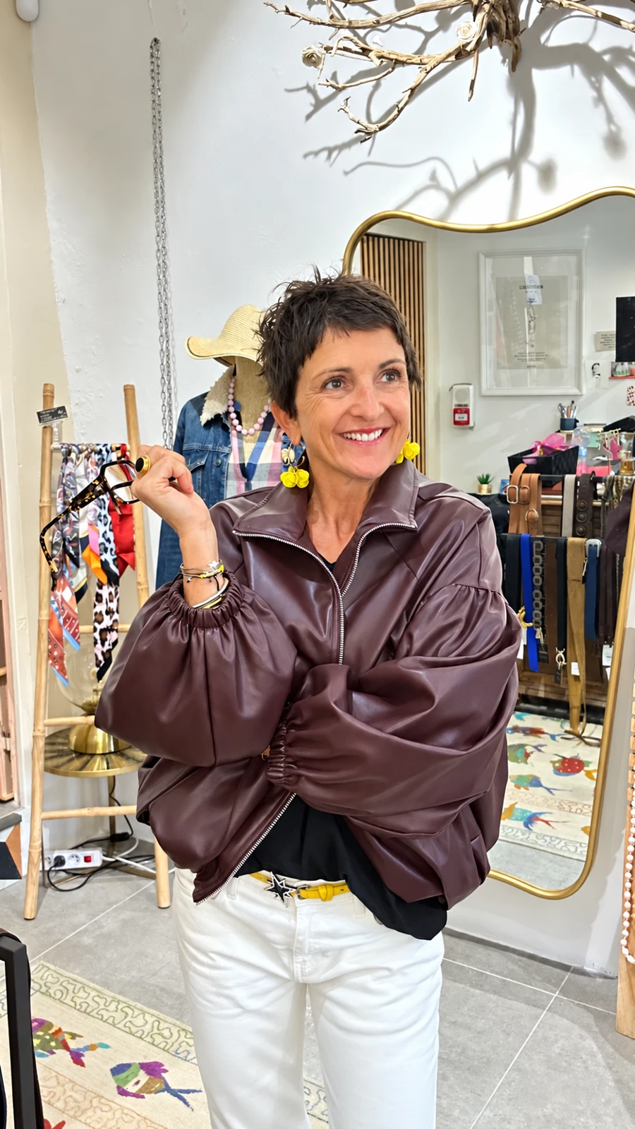 Céline souriante dans sa boutique UNiQUE, en veste prune